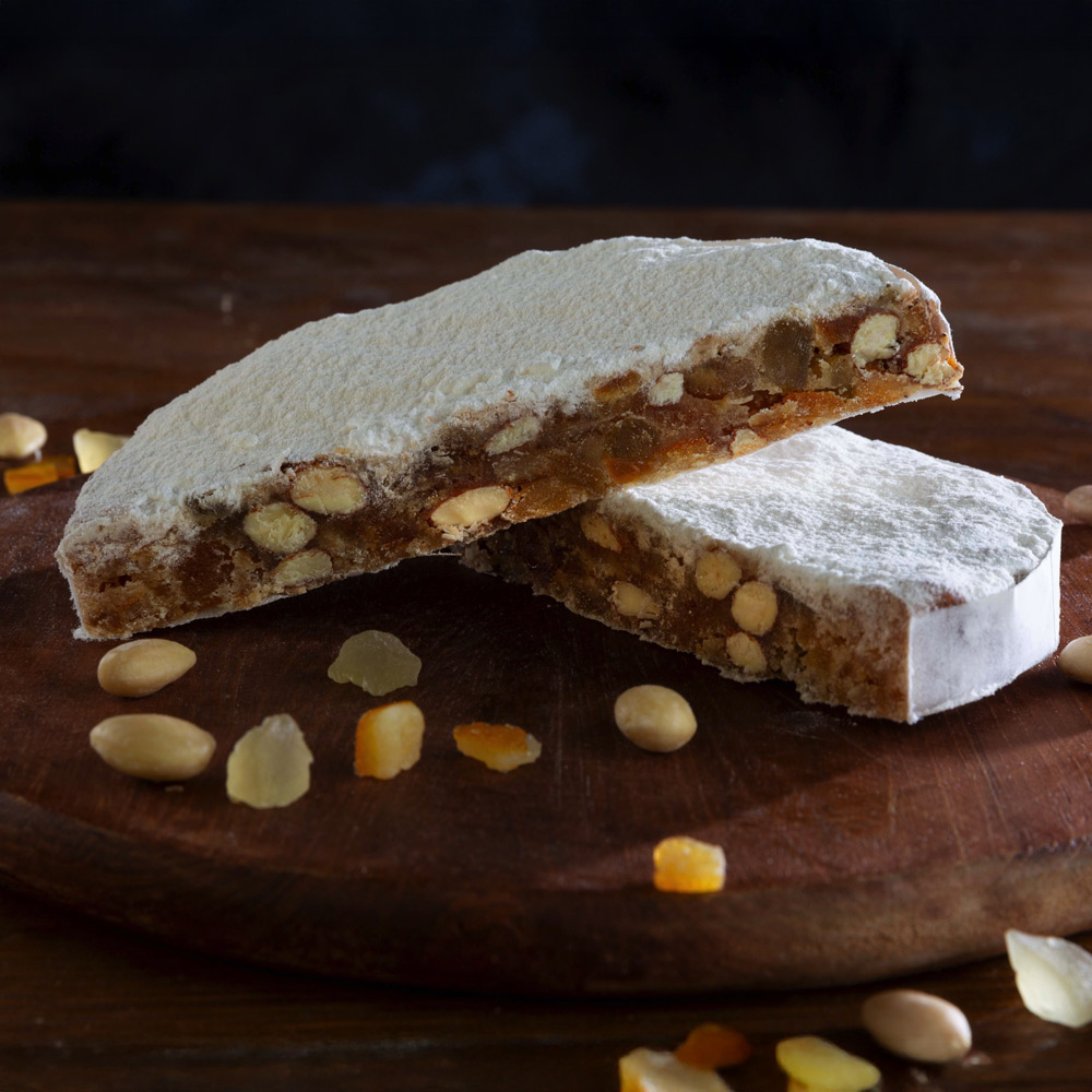 Panforte Margherita su vassoio di legno circondato da canditi